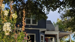 A two-story house with a porch, a front door, and a visible staircase leading to the entrance. - Spacious Victorian-Style Family Retreat | 5 Ensuite Bedrooms + Event-Ready Yard (Kanab)