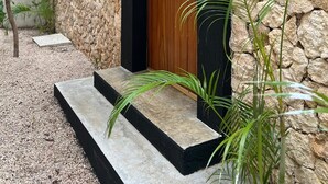 A stone building with a wooden door and steps leading up to it. - ZENDA TULUM LUXURY VILLAS (Tulum)