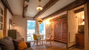 Un accogliente soggiorno con divano, poltrone, un tavolo e soffitto in legno.