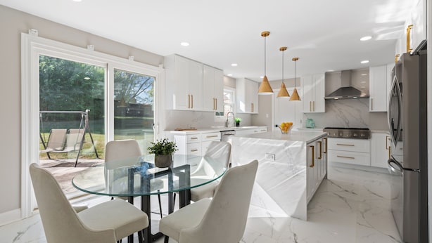 A modern kitchen with white cabinets, a glass dining table, and pendant lights. - Charming 4-bedroom house with WiFi, AC in upscale Oak Brook,near Oak brook mall (Oak Brook)