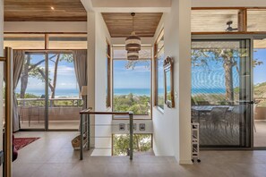 Geräumiges Interieur mit Meerblick, einer Treppe und einem Essbereich mit Außenbestuhlung.