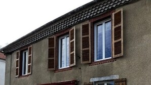 A two-story building with a tiled roof, wooden shutters, and a small porch with a red awning. - Charming 4-bedroom townhome in Rabastens-de-Bigorre at the base of the Pyrenees. (Rabastens-de-Bigorre)