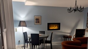 A dining area with a round table, chairs, a floor lamp, and a fireplace. - Charming 4-bedroom townhome in Rabastens-de-Bigorre at the base of the Pyrenees. (Rabastens-de-Bigorre)