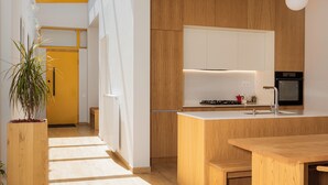 Een moderne keuken met houten kasten, een centraal eiland en een dakraam.