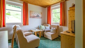 Ein gemütliches Zimmer mit zwei Sofas, einem kleinen Tisch und einem Fernseher-Schrank.