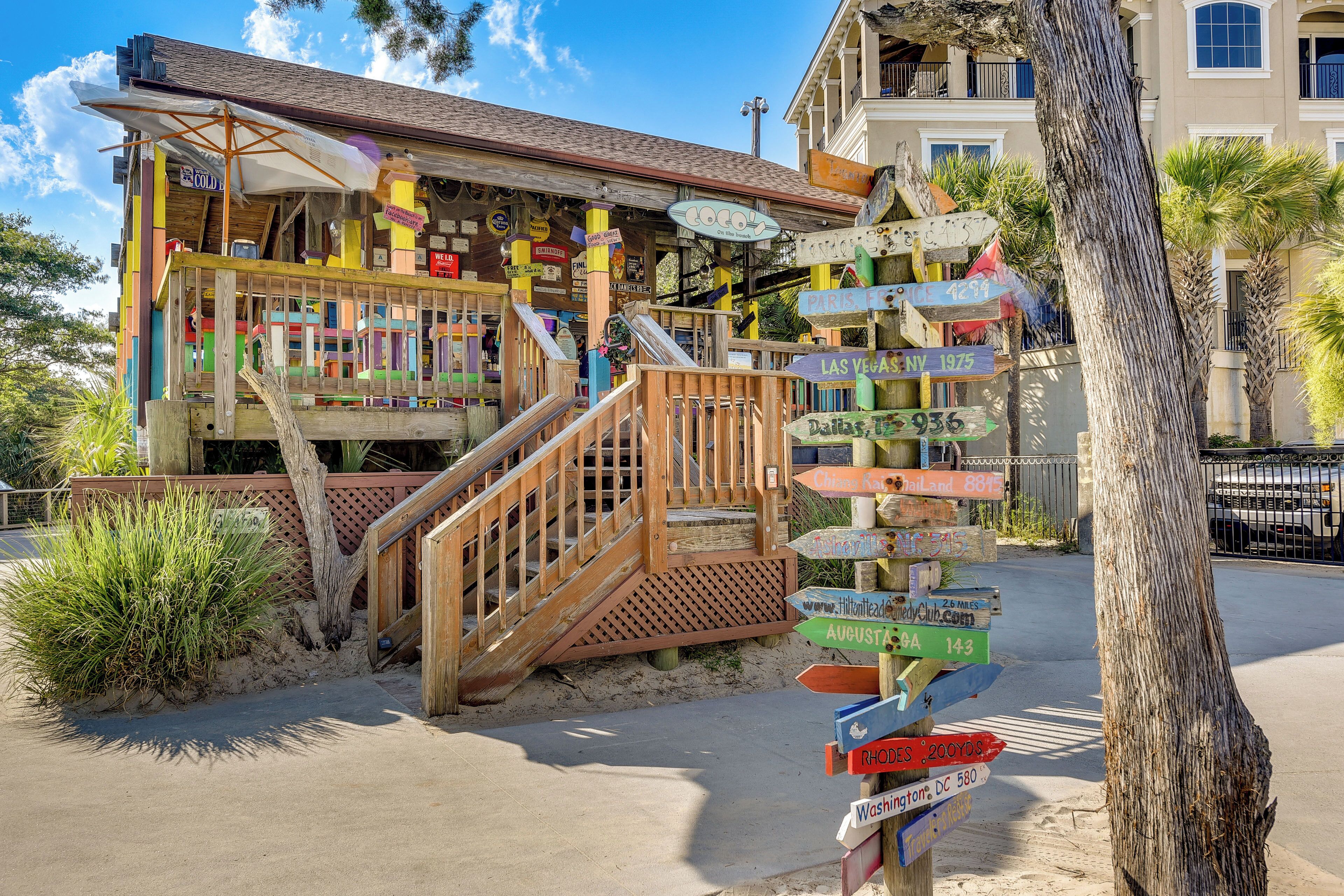 A colorful building with a wooden staircase and multiple directional signs.