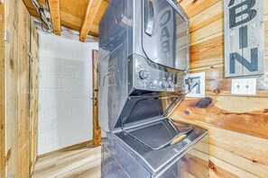 Kompakti keittiö, jossa on sisäänrakennettu uuni ja puinen seinä, jossa on kyltti, jossa lukee ”BIN”.