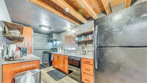 Una cocina con armarios de madera, electrodomésticos de acero inoxidable y encimera de granito.