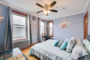 A bedroom with a bed, a ceiling fan, a window, and a radiator. - 6 Mi to Boston Common: Apt in Medford! (Medford)