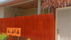 Ein roter Zaun mit einem Schild, auf dem 'ALAKA AT MAAFUSHI' steht.