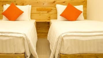 Una cama doble con ropa de cama blanca y dos almohadas naranjas.
