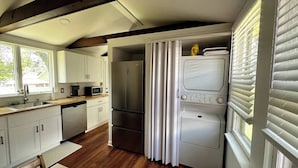 A compact kitchen with white cabinets, a stainless steel refrigerator, a microwave, and a built-in oven. - Charming 2-BRM Cottage in Tranquil Island Heights - Steps from the River (Island Heights)