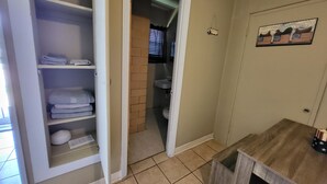 A bathroom with a toilet, sink, and towel storage. - The Americana Suite (Buchanan Dam)