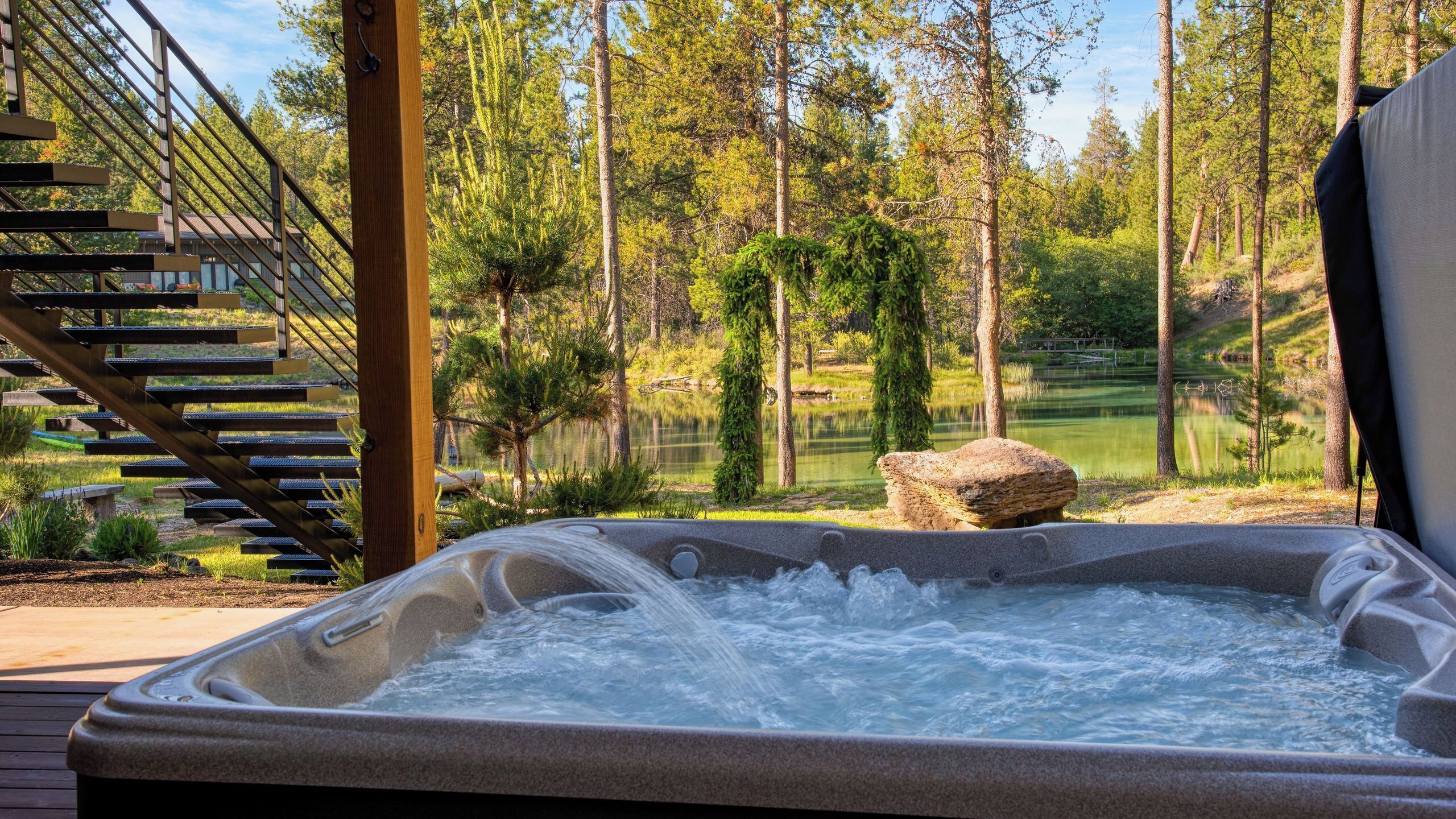 A hot tub with a view of a forest and a golf course.