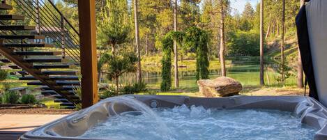 A hot tub with a view of a forest and a golf course.