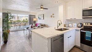 Una cocina moderna con una isla grande, electrodomésticos de acero inoxidable y vistas a la ciudad.