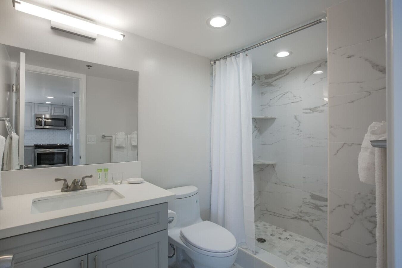 Un baño moderno con ducha, inodoro y lavabo.