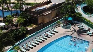 A resort with a large pool, palm trees, and a beach. - 16 FREE Parking/Ocean 1b Waikiki (Honolulu)
