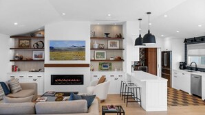 Een moderne woonkamer met een open haard, een bank en een salontafel.