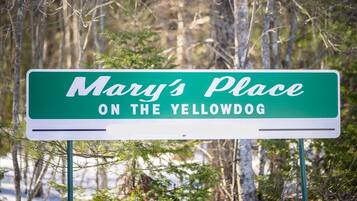 Ein Schild mit der Aufschrift 'Mary's Place ON THE YELLOWDOG' auf gelbem Hintergrund und weißer Schrift.