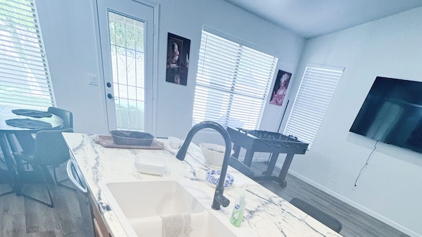 A modern kitchen with a large island, a sink, and a dining area with chairs. - Charming 3-bedroom house upscale neighborhood with WiFi, AC in awesome Glendale (Glendale)