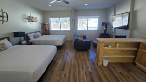 A hotel room with two beds, a wooden desk, a TV, and a window with a view of the outside. - 2 Queen Suite, Huge Deck, Free Breakfast! (Mammoth Lakes)