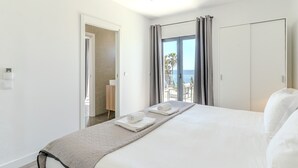 Ett hotellrum med en säng, ett badrum, en balkong med utsikt och en garderob.