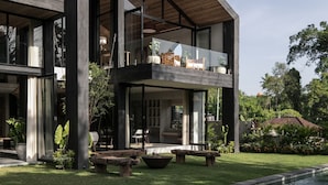 A modern two-story house with a large balcony, a swimming pool, and a well-maintained garden. - Architect 4 BDR River Villa in Nyanyi Beach (Canggu)