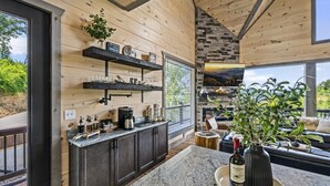 Uma cozinha moderna com paredes de madeira, bancadas de granito e lareira de pedra.