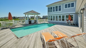 A wooden deck with a swimming pool, outdoor furniture, and a gazebo. - Waterfront Westhampton Haven: Private Beach (Westhampton Beach)