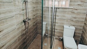A bathroom with a glass-enclosed shower, a toilet, and a sink. - The Hub Apartment Lekki (Lekki)