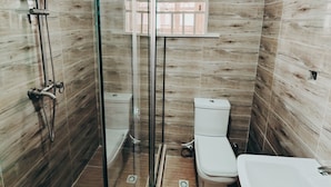 A bathroom with a glass-enclosed shower, a toilet, and a bathtub. - The Hub Apartment Lekki (Lekki)