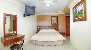 A bedroom with a bed, a dresser, a mirror, a television, and a painting on the wall. - Hotel Rincon Tarasco (Morelia)