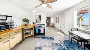 Une cuisine moderne dotée d’un îlot central, de meubles en bois, d’un four encastré et d’un ventilateur de plafond.