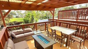 Eine Außenpatio mit Esstisch, Stühlen und einer Couch.