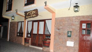 Un bâtiment doté d’une façade en pierre, de portes en bois et d’une enseigne indiquant « Hostal Mirador del Valle ».