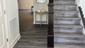 Un escalier avec des marches en bois foncé et une balustrade noire, menant à l’étage supérieur.