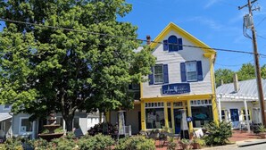 Un bâtiment à deux étages, doté d’une façade jaune et blanche, d’une porte bleue et d’une enseigne indiquant « Avery’s Bar & Grill ».