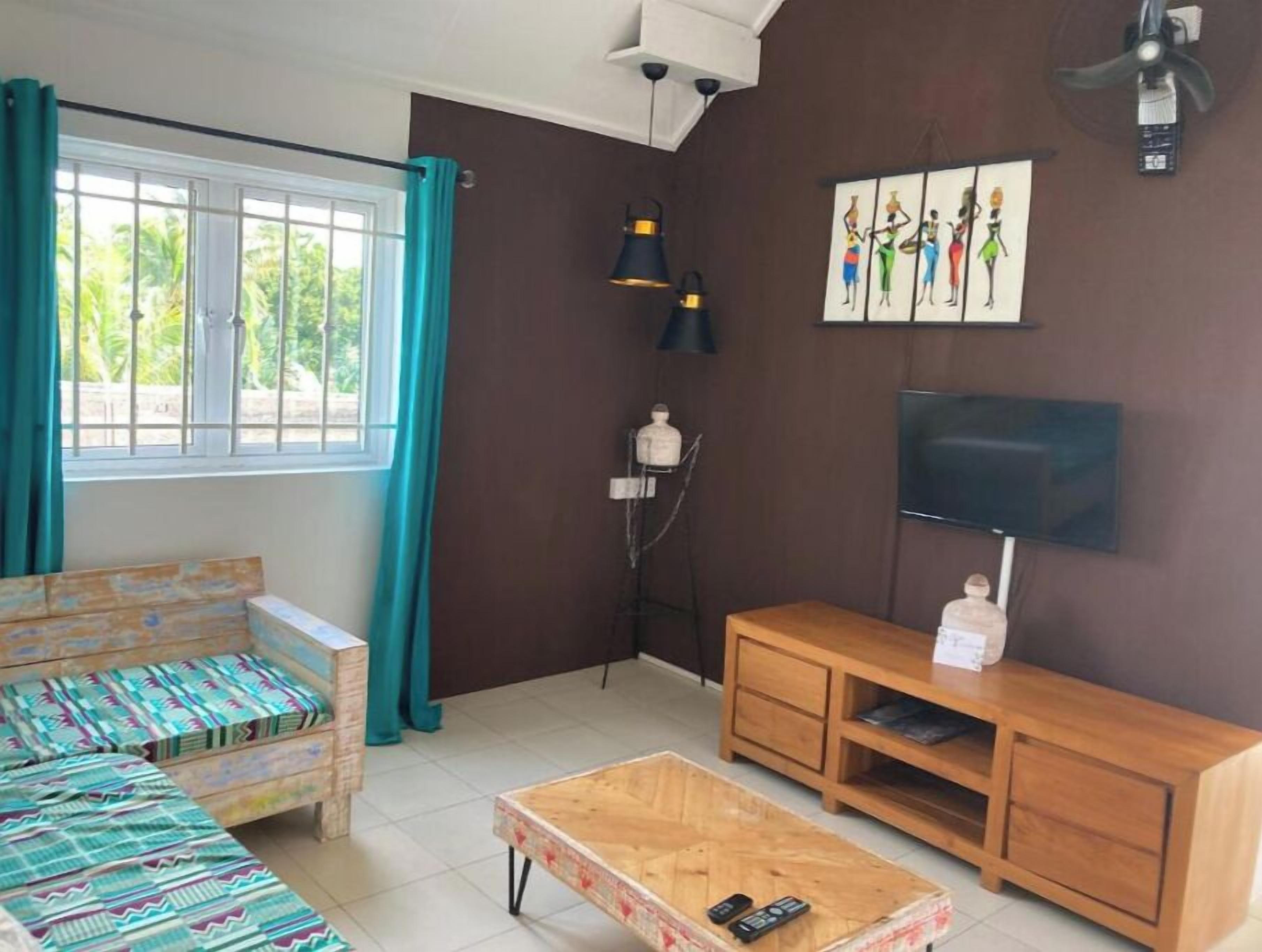 Una sala de estar con un sofá, una mesa de centro, un televisor y un cuadro en la pared.