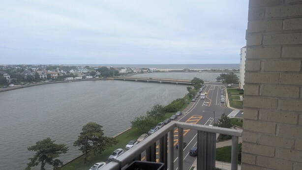 Aussicht auf einen Fluss mit einer Brücke, eine Straße mit Fahrstreifen und ein Gebäude mit Ziegelverkleidung.