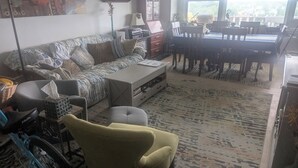 Ein Wohnzimmer mit einer Couch, einem Couchtisch und einem Essbereich mit Stühlen und einem Tisch.