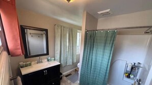 A bathroom with a vanity, mirror, and shower curtain.