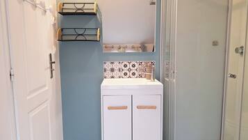 Chuveiro, secador de cabelo, toalhas de banho, papel higiênico