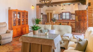 A cozy living room with a sofa set, a wooden cabinet, and a glass-top coffee table. - Casa Mirador del Mar Arenas by Ruralidays (Málaga)