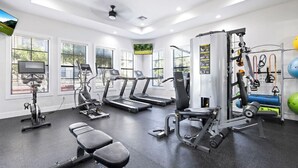 Egy edzőterem futópadokkal, súlyemelőpadokkal, súlyzókkal és fitneszlabdákkal felszerelve.