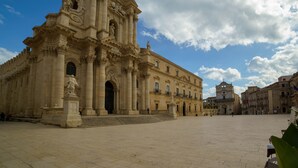 A large, historic building with a grand facade, large columns, and statues. - RE CARLO - Ortigia Luxury Suite (Siracusa)