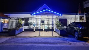Un immeuble dont l’entrée est illuminée de lumière bleue et sur lequel on peut lire l’inscription « Kwarts Appartements ».