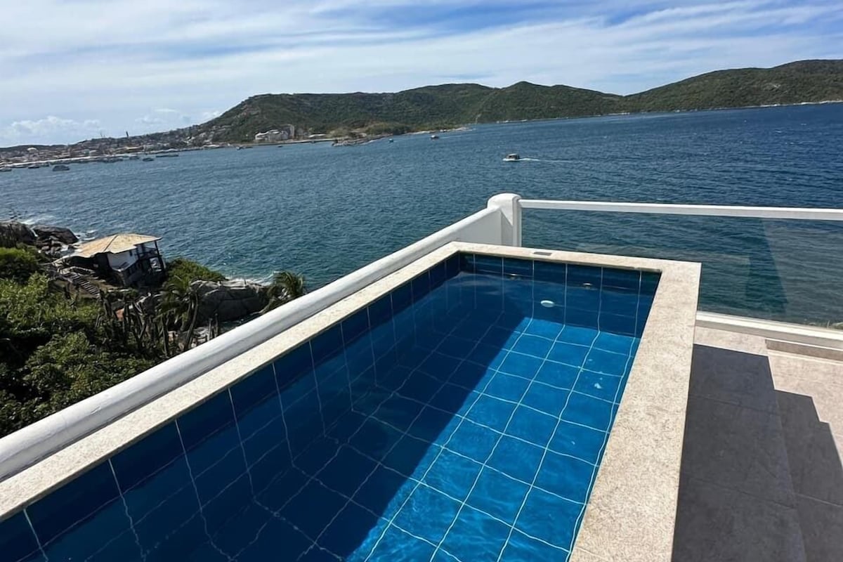 Una piscina con vistas al mar y colinas.