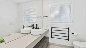 A modern bathroom with a large mirror, two sinks, a toilet, and a towel rack. - Thirty-Nine Albatross (Apartment 8) (Gold Coast)