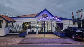A building with a blue roof and a sign that reads "Kwarts Appartenemen". - Kwarts Appartementen - Standard Studio (Paramaribo)